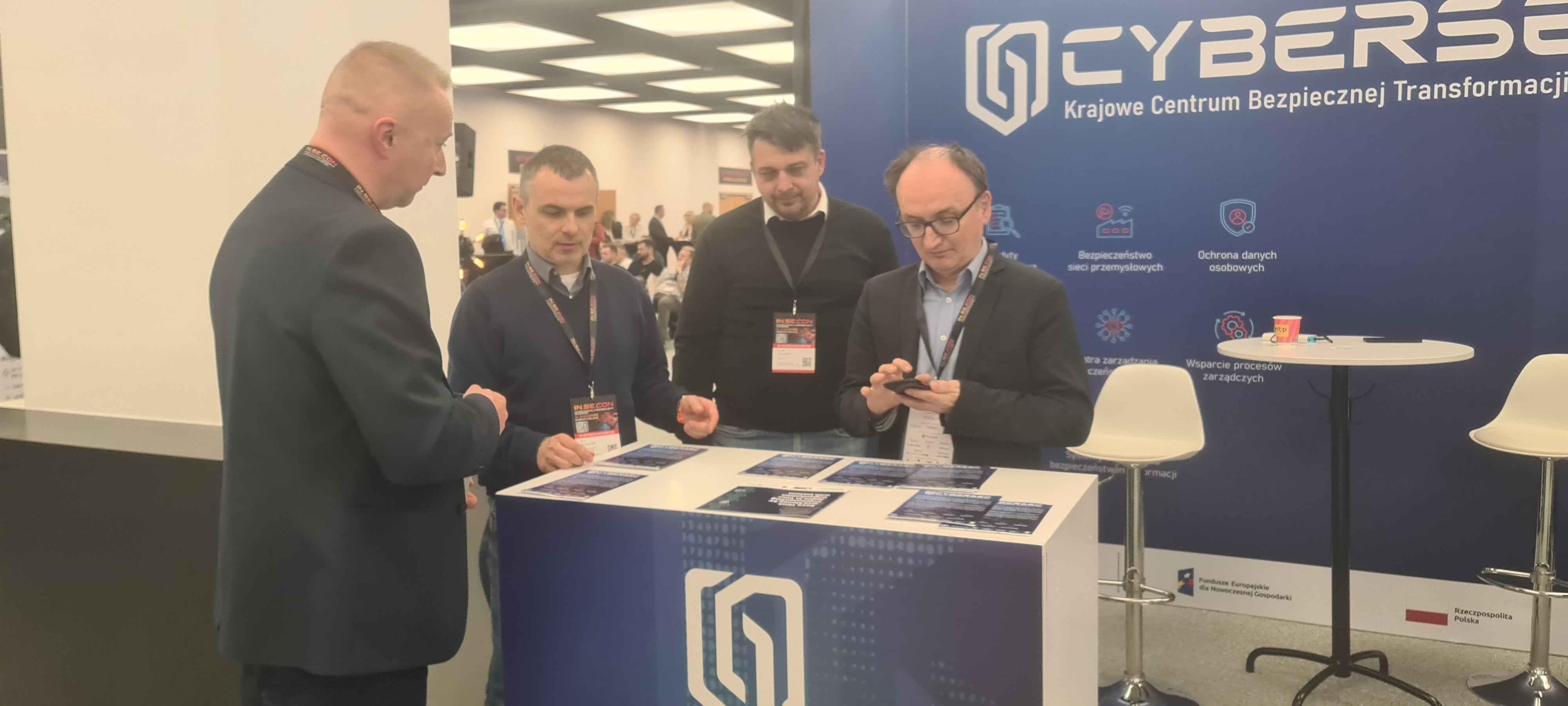 Zdjęcie przedstawicieli projektu CyberSec przy stanowisku konferencyjnym projektu.