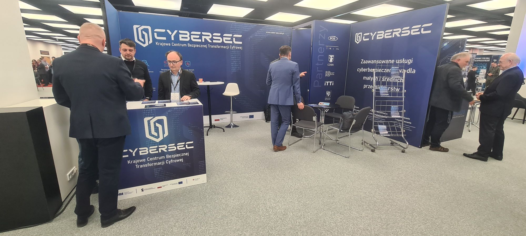 Zdjęcie przedstawicieli projektu CyberSec i osób zainteresowanych ofertą projektu (przy stanowisku konferencyjnym CyberSec). 